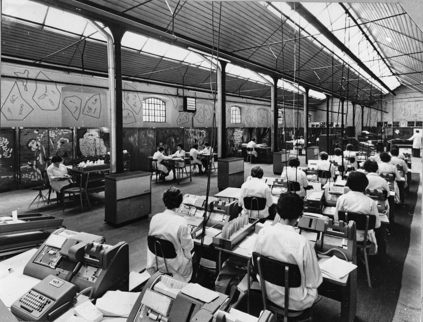 Large industrial space with many desks and women working on punchcards, as part of the large Index Thomisticus project in the 1950s.
