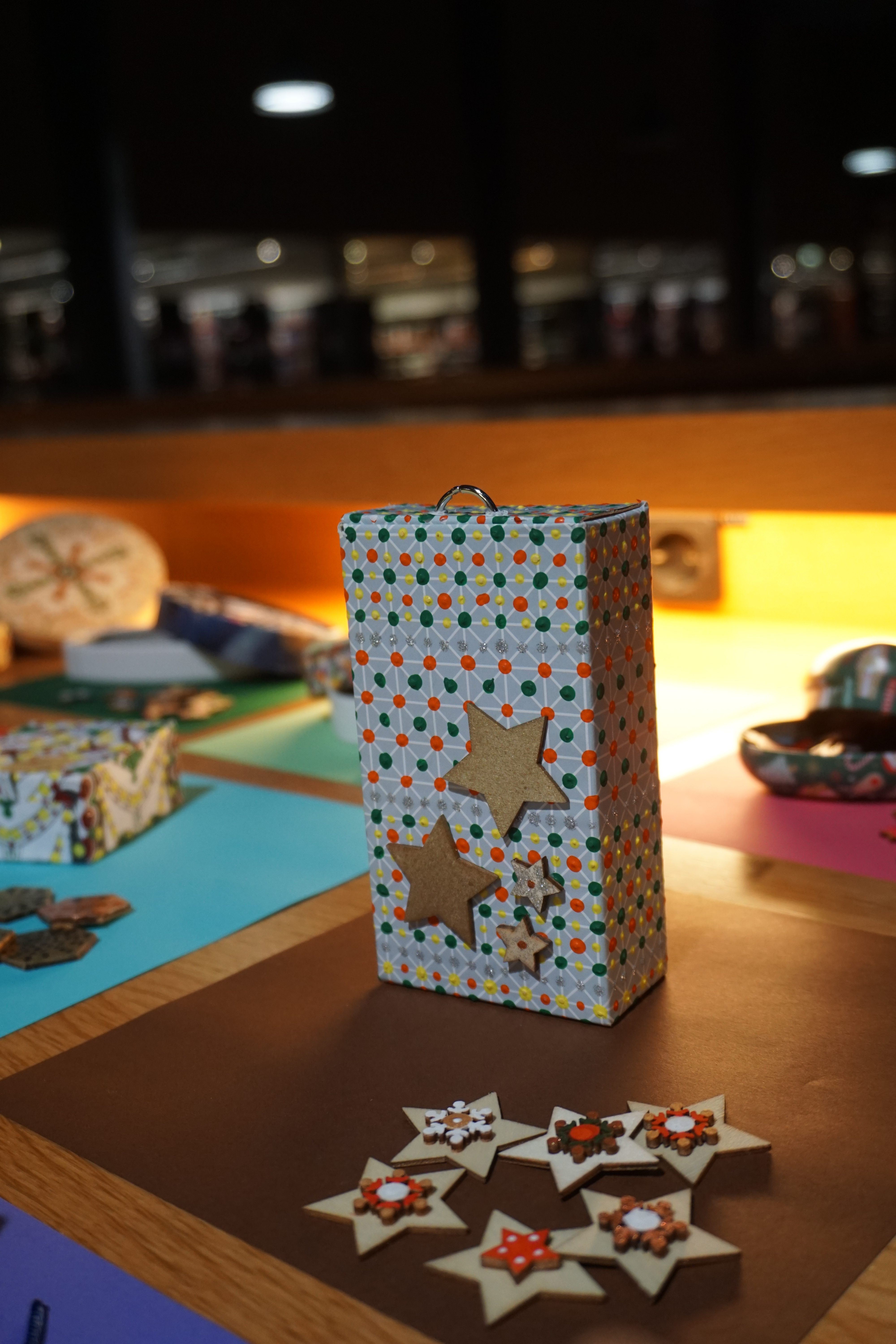 Ein Kasten mit Tupfenmuster und aufgeklebten Holzsternen, davor einzelne gestaltete Holzsterne, die als Memory-Spiel genutzt werden können.